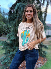 Load image into Gallery viewer, Woman wearing a graphic t-shirt with a cactus design outdoors
