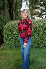 Load image into Gallery viewer, Woman wearing a red floral top and blue jeans standing outdoors
