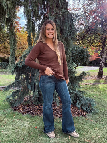 Brown long sleeve front seam sweater with v neck paired with denim jeans 